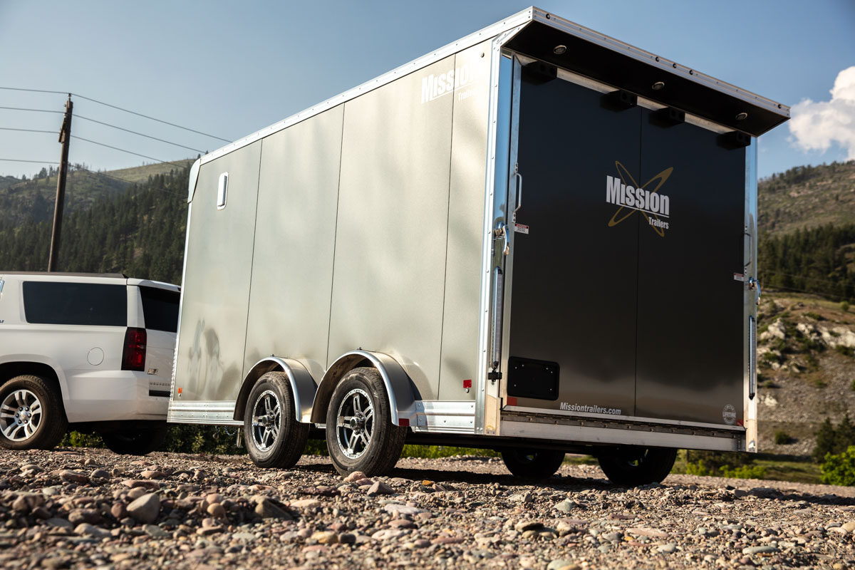 Enclosed aluminum Pinnacle Series UTV trailer parked on a gravel lot