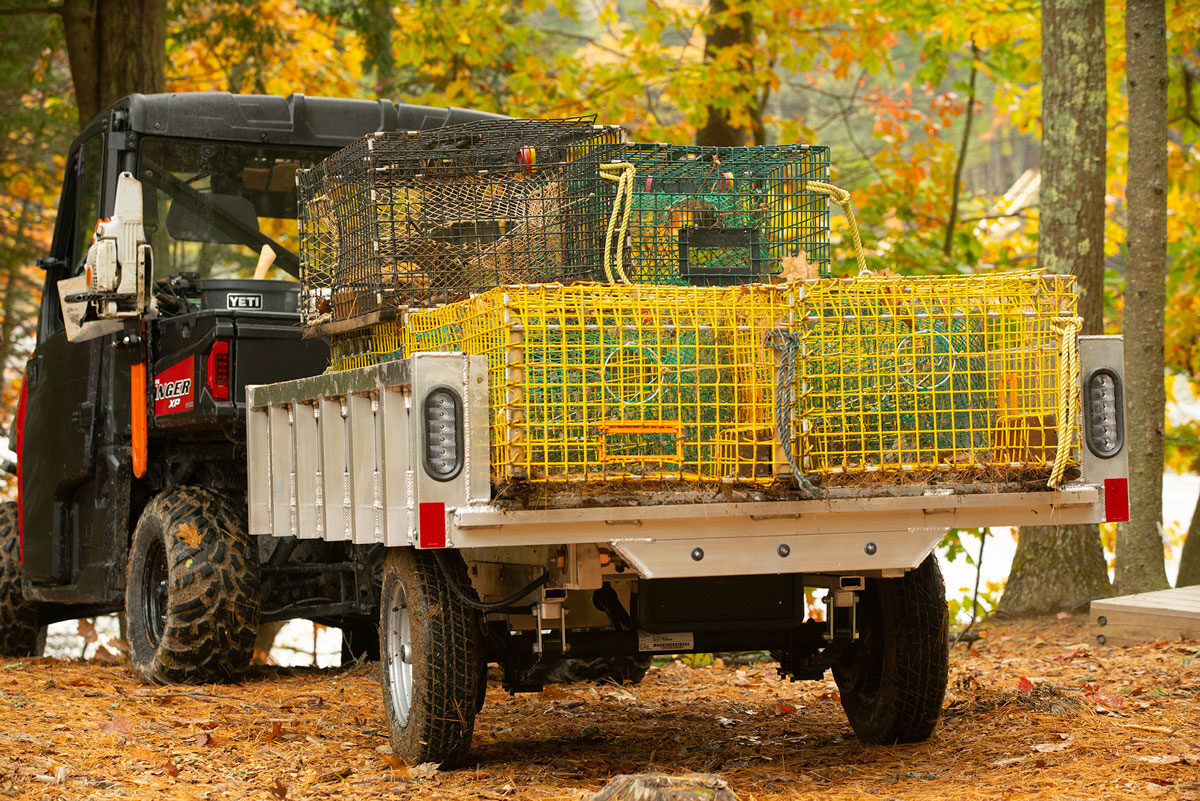 UTV towing a homeowner dump trailer that's loaded with lobster traps