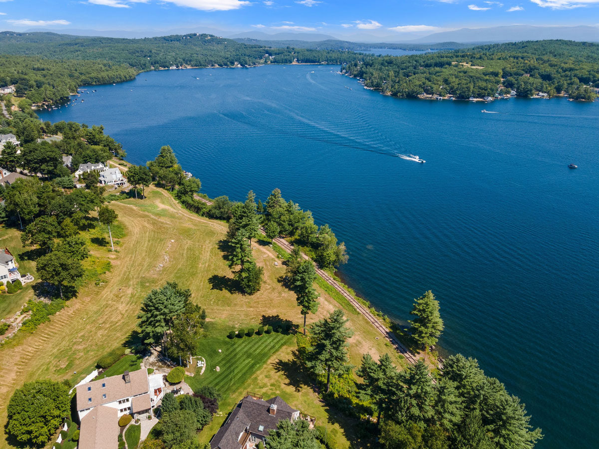 Aerial view of Lake Winnepesaukee in Massachusetts; waterfront homes and a power boat with a wake