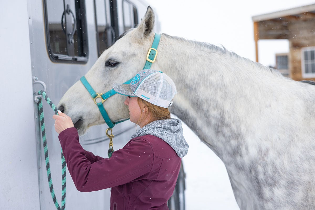Barrel racer Breanna Brown and her horse outside their Frontier aluminum trailer