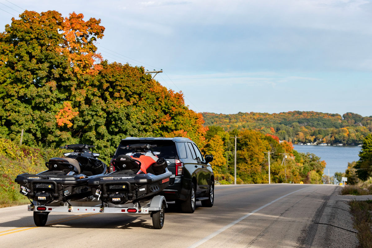 SUV towing a Triton ELITE 2-place aluminum PWC trailer to the lake