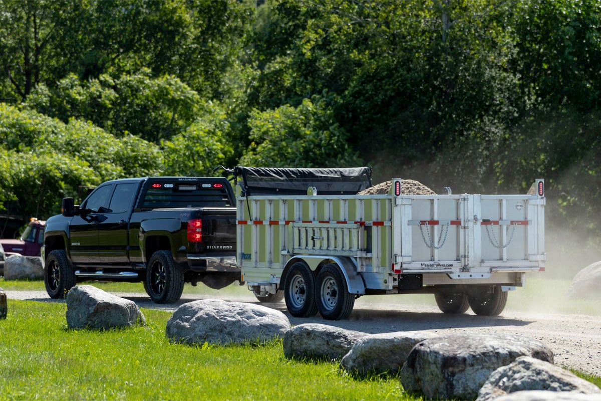 Tractor loading gravel into a commercial dump trailer from ALCOM 