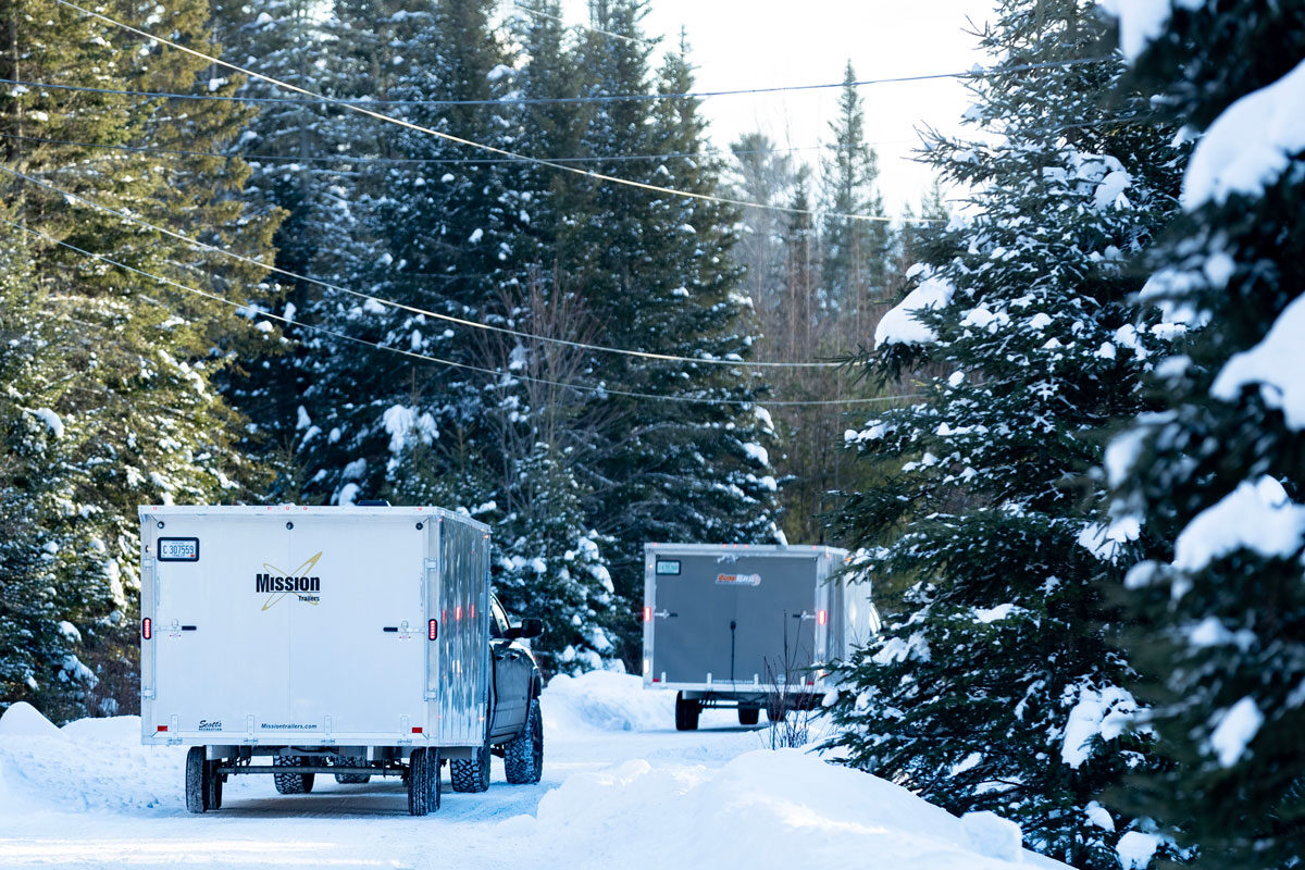 Deckover snow trailers traveling on a snowy road